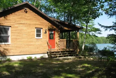 Image de Cozy Cedar Log Cabin sur Pristine Sand Pond en Norvège, idéal pour la baignade.
