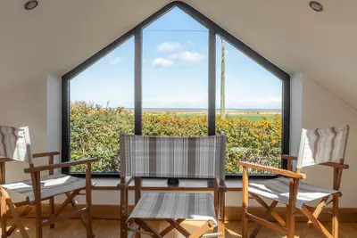Image de Une conversion de grange indépendante contemporaine de quatre chambres située sur la côte nord de Norfolk à Titchwell. C'est extrêmement spacieux et très confortable. <br>Vous avez une vue imprenable sur le marais et sur la mer depuis la plate-forme, no.