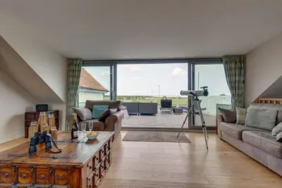 Image de Une maison confortable de style contemporain avec de fabuleuses vues dégagées sur le marais depuis le salon et le pont ouvert. Il dispose d'une élégante cuisine ouverte et salle à manger et a son propre jardin de la cour. Vous pouvez également louer la.