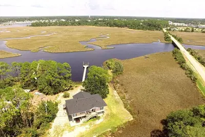 Image de Bayou Breeze est une maison au bord de l'eau située sur un terrain privé d'un acre surplombant le Postun Bayou.