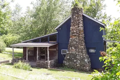 Image de Ce lodge à la ferme spacieux et confortable possède une cheminée en pierre et peut accueillir de 9 à 10 personnes.