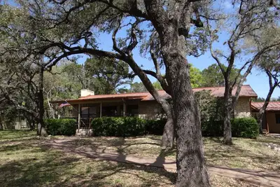 Image de Maison de style lodge, beau terrain, cuisine extérieure et grand bain à remous