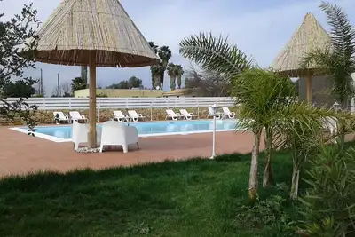 Image de villa de prestige avec piscine entourée de verdure près de la mer
