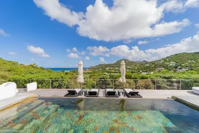 Image de Piscine à débordement avec bordure en pierre, belvédère sur la terrasse conçue pour les repas Alfresco