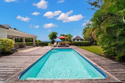 Image de Oasis tropicale en bord de mer avec piscine - hauts arbres