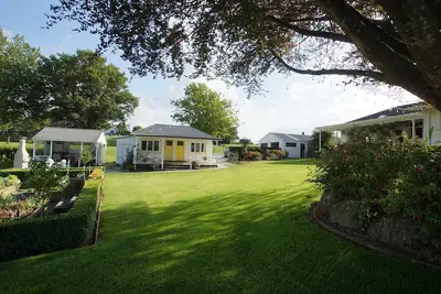 Image de Karapiro Country Cottages - 3 dans un jardin de campagne bordant une réserve indigène