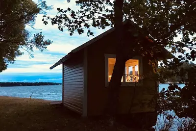 Image de Cottage avec terrasse en bois ensoleillée au bord de l'eau