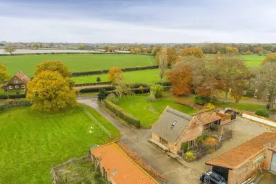 Image de Situé au milieu des terres agricoles, cette grange offre une retraite rurale de luxe paisible.