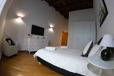 Image de Grand appartement lumineux, avec des murs blancs de 4 mètres de haut avec des poutres en bois.
