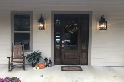 Image de Maison à aire ouverte de 5 chambres nichée au milieu des pins sur une route calme.