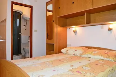 Image de Maison familiale avec quatre appartements de trois studios et un appartement pour 4 personnes est située sur l'île de Pag dans la ville de Pag, dans un endroit très calme, à 10 minutes à pied de la place principale de Pag et à 15 minutes de la plage de.