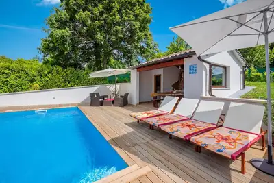 Image de Villa ensoleillée avec piscine privée, chaises longues, douche extérieure.