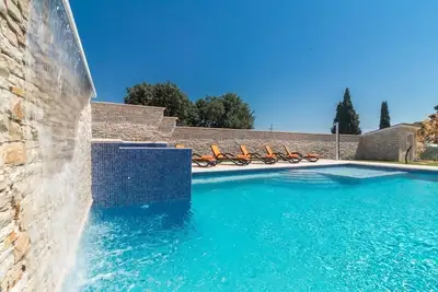 Image de Villa pour les grandes demandes avec grande piscine, sauna, bain à remous, équipement de fitness, billard et cuisine extérieure professionnelle.