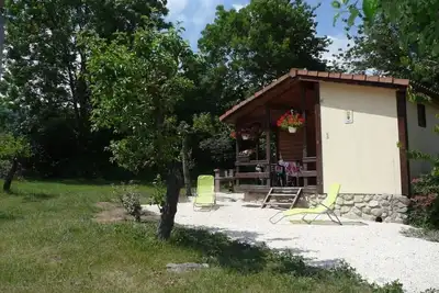 Image de chalets en bois dans village de gites avec terrasse, barbecue, piscine et clim