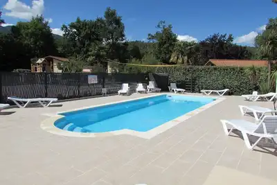 Image de chalets en bois dans village de gites avec terrasse, barbecue, piscine et clim