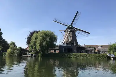 Image de Beau moulin à vent original le long de la rivière