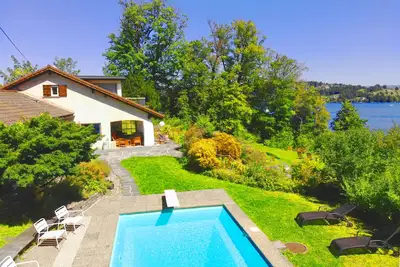 Image de Villa directement au bord du lac avec piscine privée, propre plage et hangar à bateaux