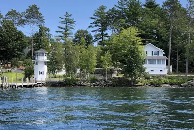 Image de Lakefront Cottage avec phare et quai sur le lac Winnipesaukee