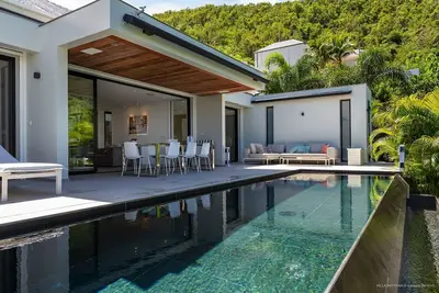 Image de Villa nouvellement construite donne sur un paysage de collines verdoyantes, de palmiers, d'arbres flamboyants orange et o