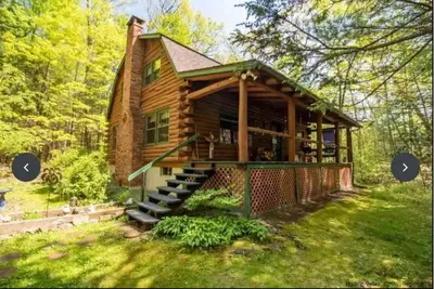 Image de Une cabane en rondins moderne \"à la pointe de la technologie\" nichée dans une propriété boisée sereine.