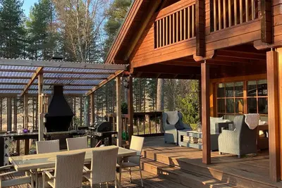 Image de Maison avec sauna, barbecue, bain à remous et grande terrasse au bord du lac.