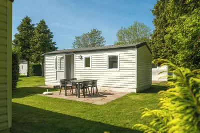 Image de Mobile home individuel pour quatre personnes, meublé simplement.