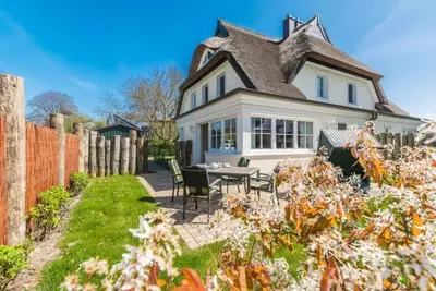 Image de maison jumelée au toit de chaume exclusif avec cheminée et sauna en première position