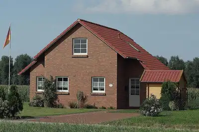 Image de Confortable Friesenhaus quatre étoiles avec une jetée et une terrasse sur les canaux