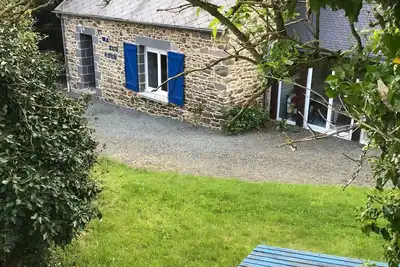 Image de maison de charme sur terrain et forêt dans un écrin de verdure calme garanti.