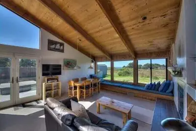Image de Wide open meadow view with ocean peeks through the trees.