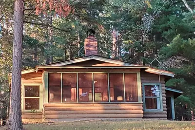 Image de Rustic cabin in remote wooded area on point overlooking lake.