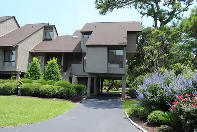 Villa with landscape view and pool access located within gated Litchfield By the Sea community.