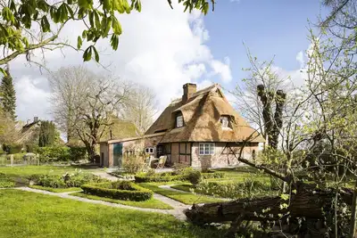 Image de Gem under thatch with historic wood-burning stove and dreamlike garden