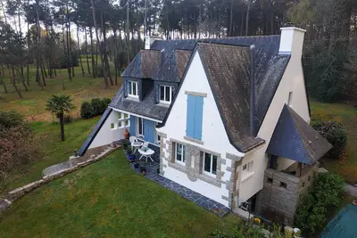Image de Maison Néo-Bretonne dans un parc arboré.