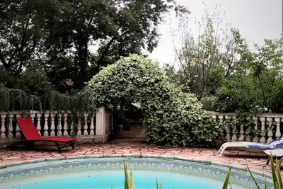 Image de Agréable Studio  dans jardin paysager  avec piscine et grande cuisine d'été.