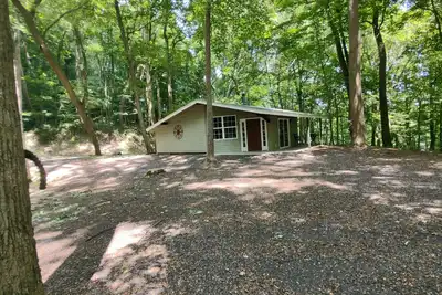 Image de The Chalet is located in the woods of a gated property with a covered porch.