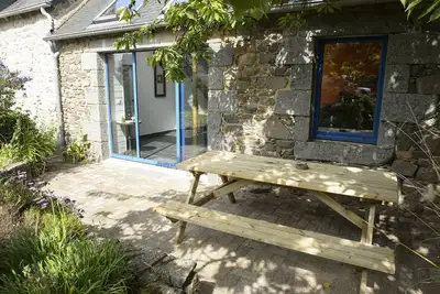 Image de maison en pierres avec terrasse et jardin