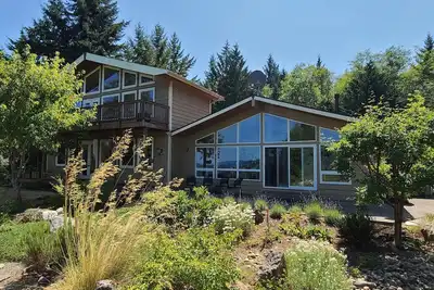 Image de Modern retreat with serene canal, forest, and mountain views.
