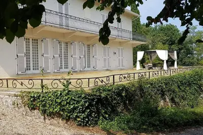 Image de Maison coloniale entourée de falaises et d'arbres