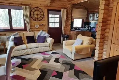 Image de Lakeside Log Cabin with hot tub overlooking the water.