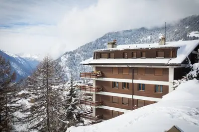 Image de Un grand hall d’entrée, un séjour avec coin à manger et une cheminée, une cuisine équipée avec lave-