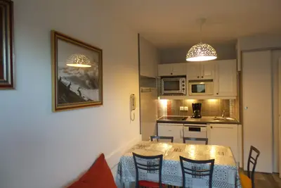 Image de appartement au 1er étage avec vue sur les pistes départ  skis aux pieds.