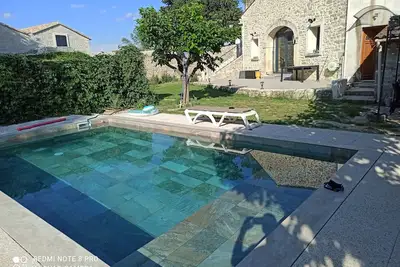 Image de Maison en pierre rénovée dans un style contemporain avec jardin et piscine.