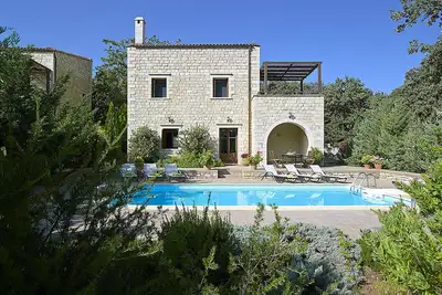 Stone villa with pool in the middle of green hills
