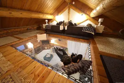 Image de This beautiful log cottage has large windows that let in lots of light