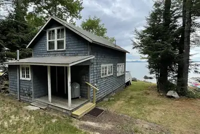 Rustic shorefront cottage with a small sandy beach