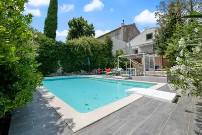Image de Grande villa familiale avec terrasses ombragées, jardin et piscine.