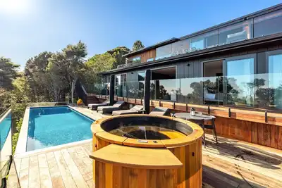 Image de Kaitiaki Lodge - Kaitiaki Lodge is our brand new luxury lodge located in Onetangi on Waiheke Island. Situated overlooking acres of unspoilt native bush with the Hauraki Gulf beyond the setting is simply spectacular. The lodge has 5 large bedrooms, 3.