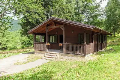 Image de Chalet Castagno - Villaggio Anemone avec vue sur les montagnes et terrasse.