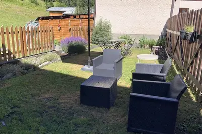 Image de Maison de village au milieu des montagnes avec jardin.
